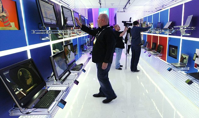 A man looks over the collection of laptops running the Windows operating system at the Microsoft booth on the opening day of the International Consumer Electronics Show