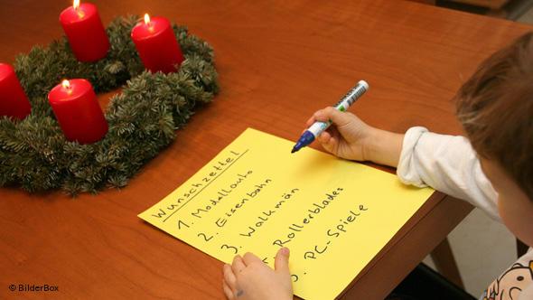 کودکی در حال نوشتن آرزوهای خود برای دریافت هدیه