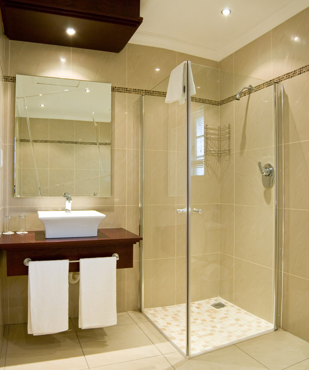 Luxury-shower-cabin-with-glass-doors-and-mosaic-floor-washbasin-with-mirror