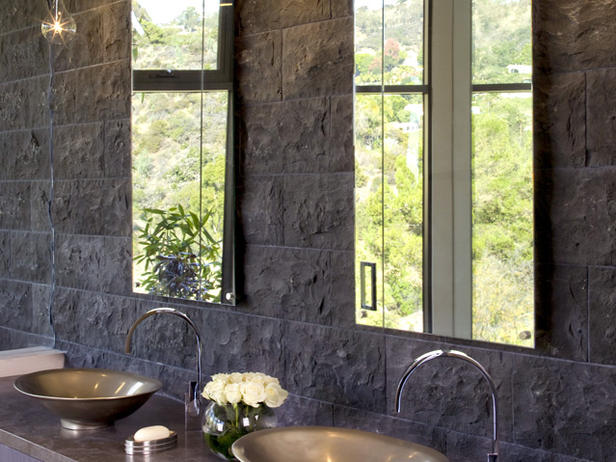 Bathroom-with-lava rock wall, glass teardrop-shaped-pendants-a-bronze-bowl-and-chrome-faucets